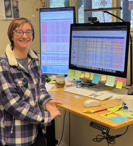 Maia in her office with her intricate colorful spreadsheets and sticky notes