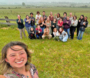 An image taken by Aly Liu using a selfie perspective of 22 people posed in a field, who all gathered for a celebration at the end of the the first offering of Novel Marine Ecosystems course in spring 2024.